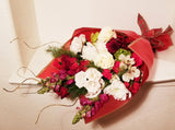 This winter fresh seasonal bouquet of timeless ivory roses, breathtaking white roses, white Snapdragon, Carnations, Mums, and seasonal greens and more is sure to wow your lucky loved one.