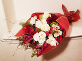 This winter fresh seasonal bouquet of timeless ivory roses, breathtaking white roses, white Snapdragon, Carnations, Mums, and seasonal greens and more is sure to wow your lucky loved one.