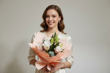 Bouquet of Roselily flowers with pink paper wrap against a plain background (Fragrant & Long-Lasting) 