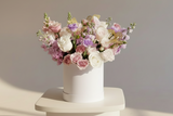 Pink, lavender and creamy flowers such as roses, spray roses, stocks tulips, snapdragons chrysanthemum  sophistically arranged with lush greenery and fillers.
(Flower: Flowers/Hatbox Color and variety may vary) 