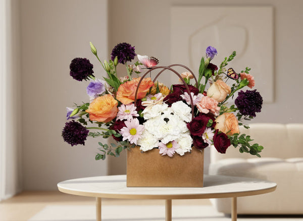 Floral arrangement with a white dog in a brown paper bag on a light gray background