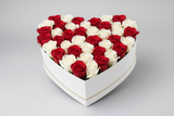 Heart-shaped box filled with red and white roses on a light gray background