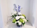 Floral arrangement with white, green, and blue, green and white flowers 