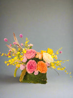 Purse Of Happiness features a mossed “purse” tucked overflowing with the sweetest Roses, seasonal flowers and greenery.