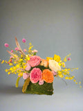 Purse Of Happiness features a mossed “purse” tucked overflowing with the sweetest Roses, seasonal flowers and greenery.