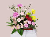Small mix of seasonal flowers and greenery design in tray. 