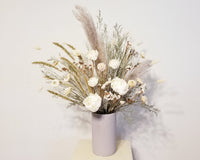 This all dried floral arrangement will last you forever and ever! Designed with a mix of Sola Wood, dried flowers in whites & cream in modern white ceramic speckle vase. 