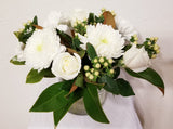 glorious arrangement evokes the splendor of winter in a forest. white Roses, Carnations, Holly Berries, Chrysanthemums, Poms, and magnolia tips