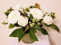 glorious arrangement evokes the splendor of winter in a forest. white Roses, Carnations, Holly Berries, Chrysanthemums, Poms, and magnolia tips