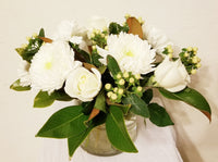 glorious arrangement evokes the splendor of winter in a forest. white Roses, Carnations, Holly Berries, Chrysanthemums, Poms, and magnolia tips