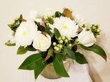 glorious arrangement evokes the splendor of winter in a forest. white Roses, Carnations, Holly Berries, Chrysanthemums, Poms, and magnolia tips