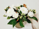 glorious arrangement evokes the splendor of winter in a forest. white Roses, Carnations, Holly Berries, Chrysanthemums, Poms, and magnolia tips