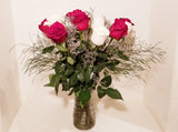 This cheerful design arranged with dozen of red and white roses and fillers, and accented with assorted with greens in clear vase. 