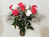 This cheerful design arranged with dozen of red and white roses and fillers, and accented with assorted with greens in clear vase. 